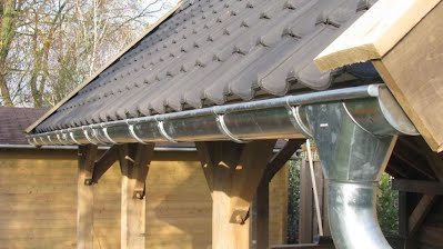 Zinken dakgoot onder een dak met dakpannen